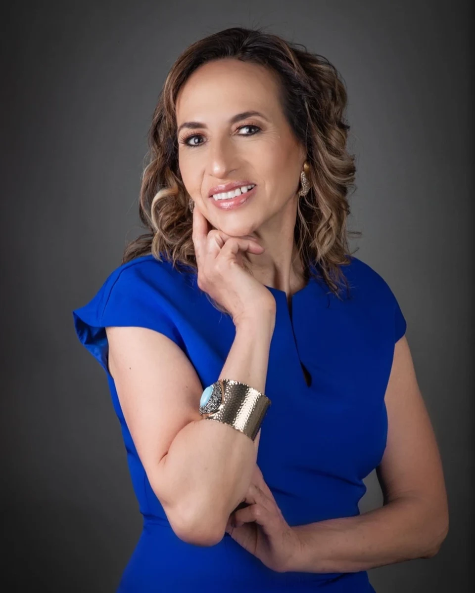 Retrato con vestido azul y mano junto al rostro.
