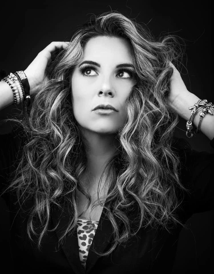 Primer plano en blanco y negro con manos sobre el cabello.