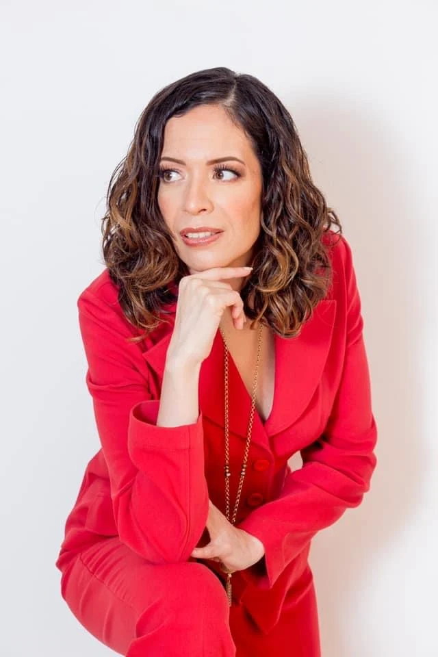 Retrato con traje rojo sobre fondo claro.