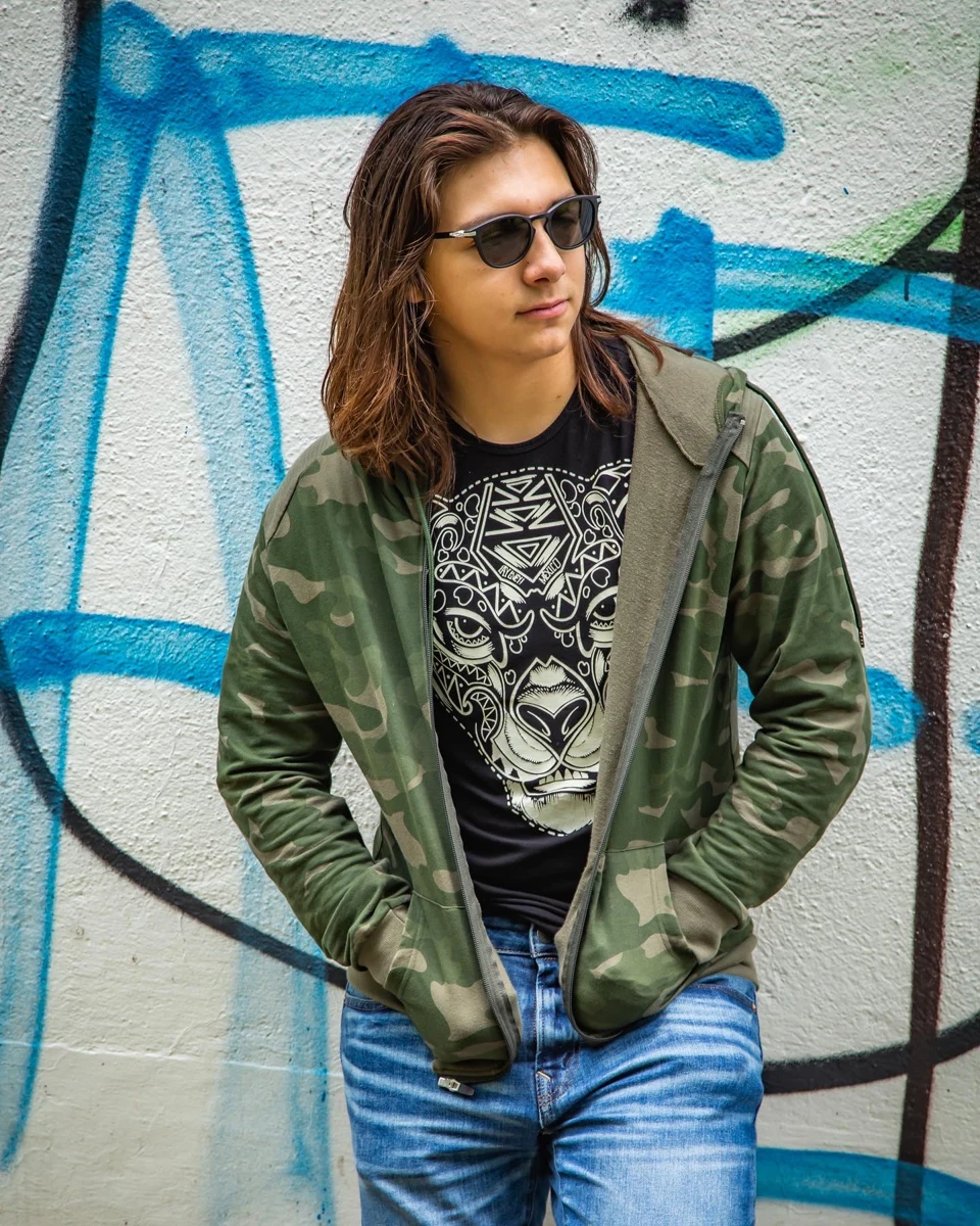 Retrato con chaqueta verde frente a un mural.