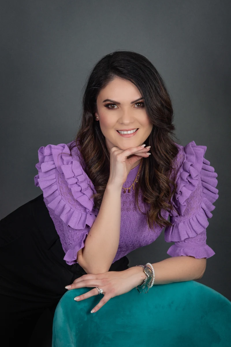 Retrato con blusa morada y pantalón verde.